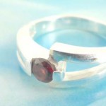 Favorite 925. stamped silver ring holding round ruby rhinestone with V shape design